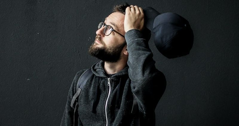 man looking up holding his hair