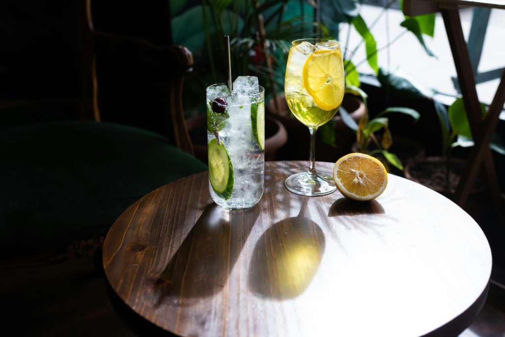 Cocktail drinks on a wooden table representing intermittent drinking and mindful alcohol consumption.