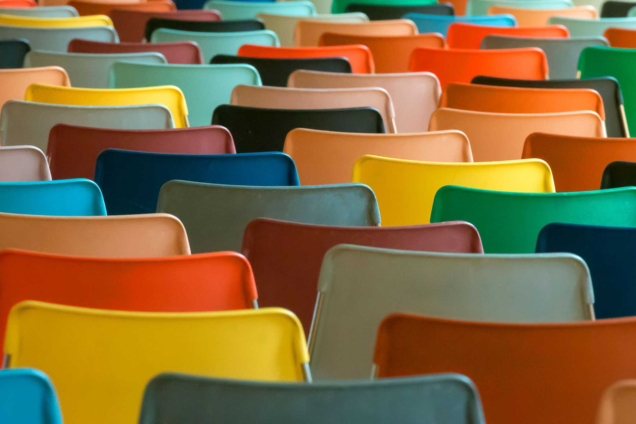 Rows of colorful chairs representing the meeting spaces used for Moderation Management group discussions and community gatherings.
